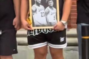 球迷手持詹姆斯和布朗尼的黑白畫框合照在外灘等待